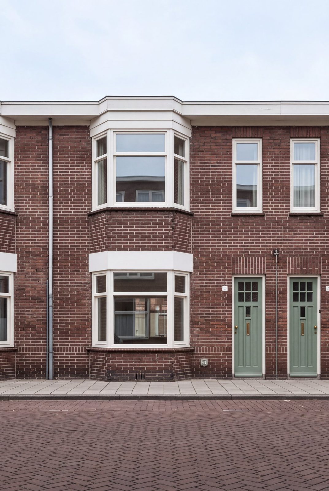Rijwoning aan de Valeriusstraat met twee erkers boven elkaar en een groene voordeur